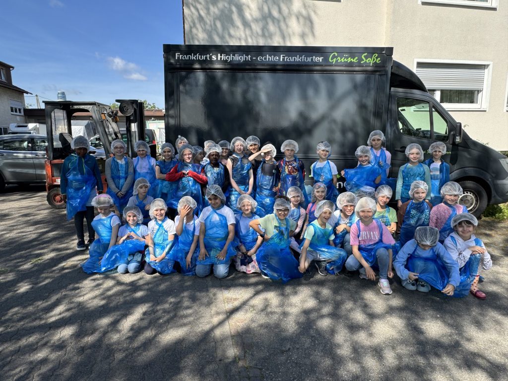 Klassenfoto der Kinder in blauen Shirts vor dem Bus bei der Grünen Lunge