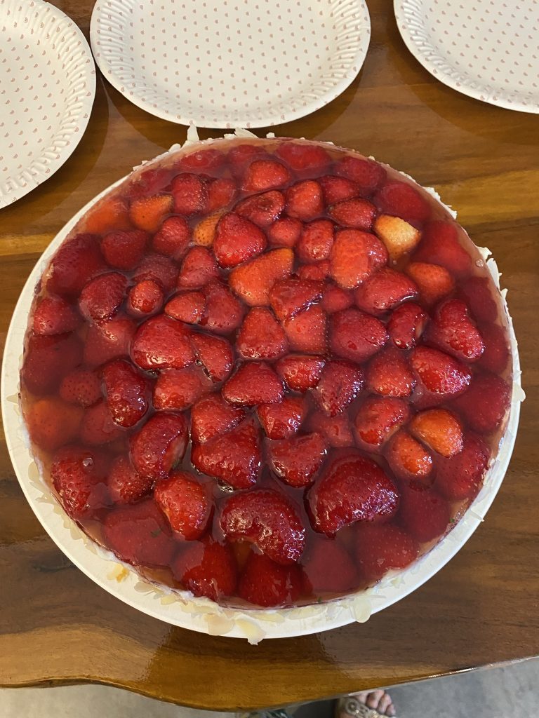 Ganzer Erdbeerkuchen von oben auf einem Holztisch beim Mathe-Ausflug der Mathematik-Forder-AG ins Café Kling
