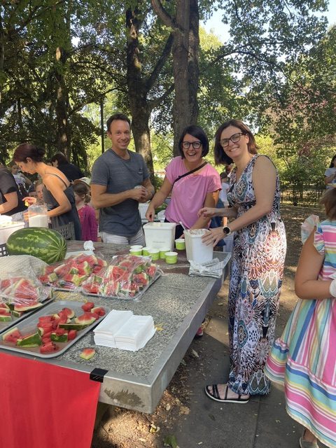 Helferinnen und Helfer des biLiS-Vereins verteilen Wassermelone und Eis beim Ferragosto-Fest der Mühlbergschule