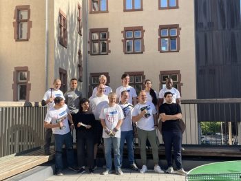 Gruppenfoto des Teams von BNP Paribas mit Akkuschraubern und Handschuhen auf dem Schulhof der Mühlbergschule beim Malteser Social Day