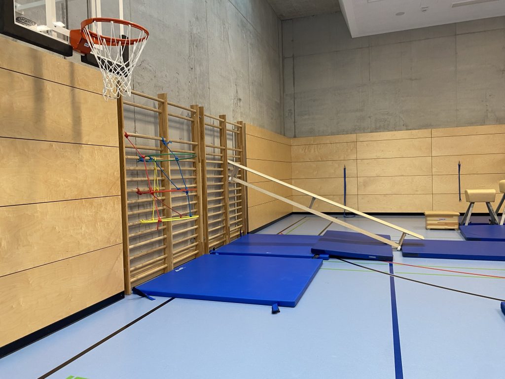 Eingehängte Bank an der Sprossenwand mit Matten davor, Station des Be Active Day Parcours