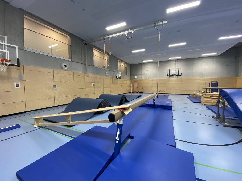 Schwebebalken mit aufgelegter Bank und Matten in der Turnhalle, Be Active Day Parcours