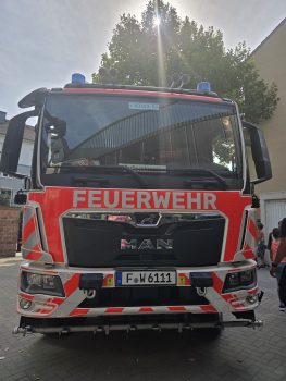 Frontansicht eines Feuerwehrfahrzeugs im Hof, Brandschutzerziehung der Feuerwehr für Jahrgang 4