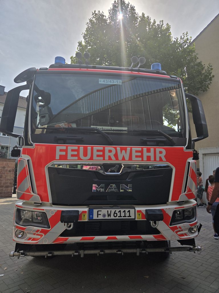 Frontansicht eines Feuerwehrfahrzeugs im Hof, Brandschutzerziehung der Feuerwehr für Jahrgang 4