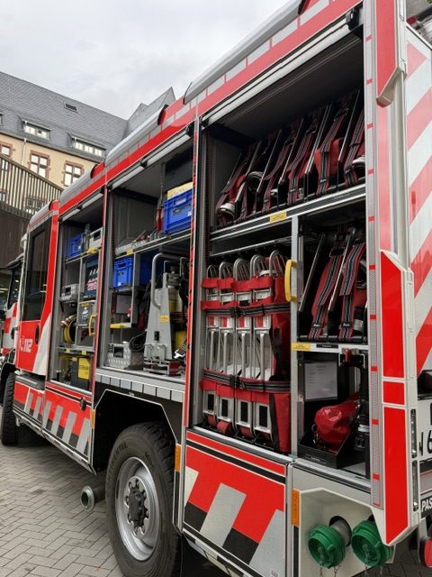 Geöffnete Gerätefächer eines Feuerwehrfahrzeugs mit Ausrüstung, Brandschutzerziehung der Feuerwehr Jahrgang 4