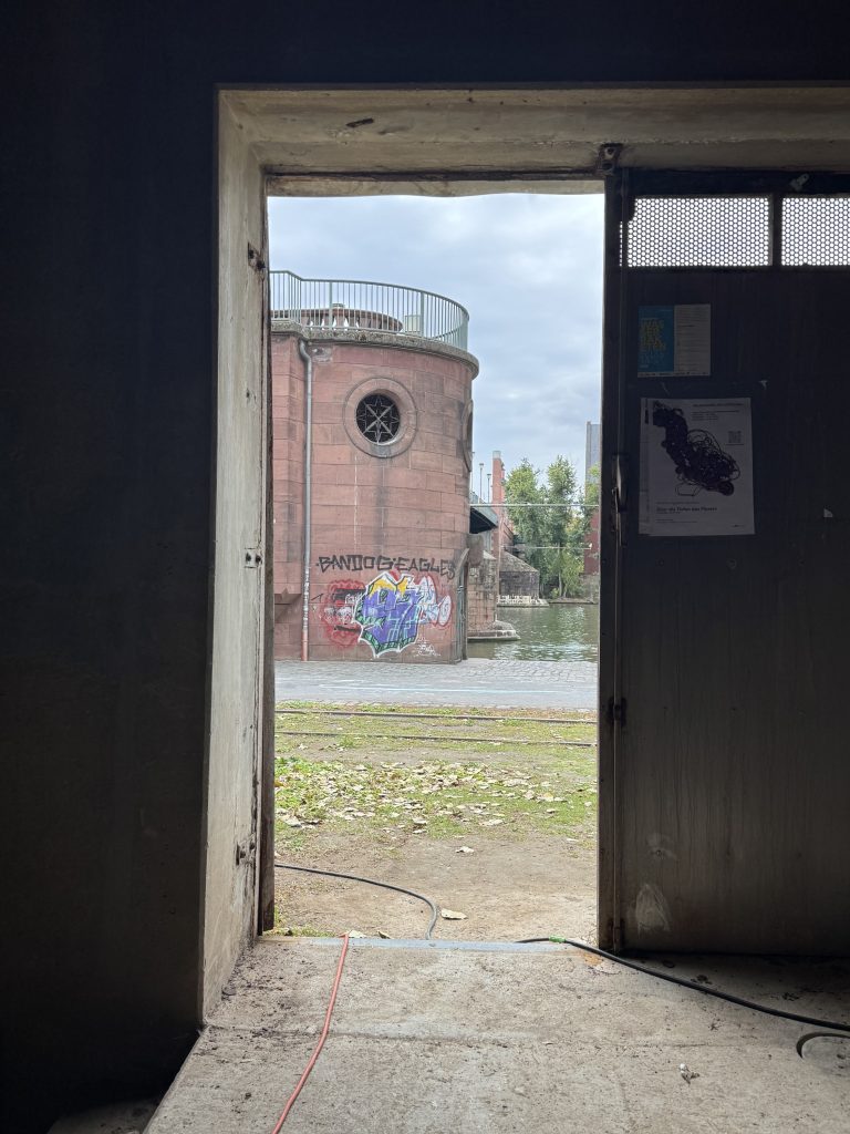 Blick durch eine Tür der Fischerhallen auf den Brückenturm am Mainufer, Frankfurt