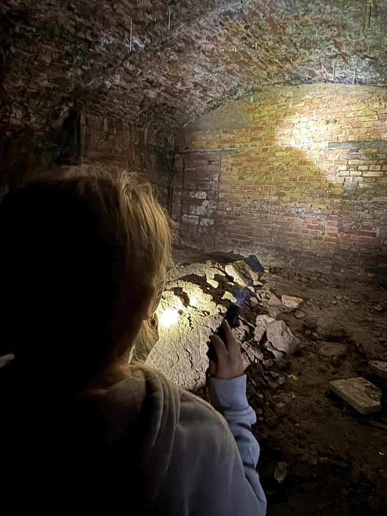 Kind leuchtet mit Taschenlampe in ein Backsteingewölbe der Fischerhallen unter der Alten Brücke Frankfurt