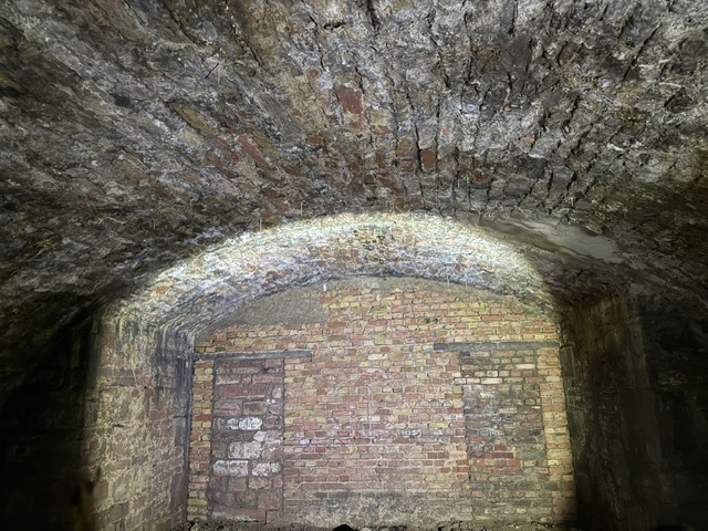 Angeleuchtetes Backsteingewölbe mit zugemauertem Durchgang in den Fischerhallen unter der Alten Brücke