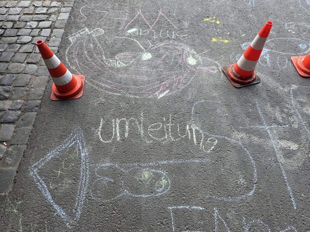 Kreidebild mit Pfeil und Schriftzug Umleitung zwischen Verkehrshütchen auf dem Asphalt, Fischerhallen Frankfurt