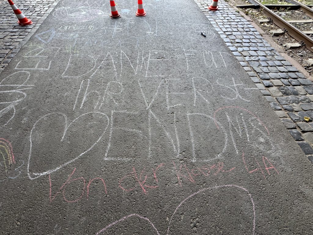 Kreideschrift mit Herz und Dank auf dem Asphalt neben den Gleisen, Abschluss des Besuchs der Fischerhallen
