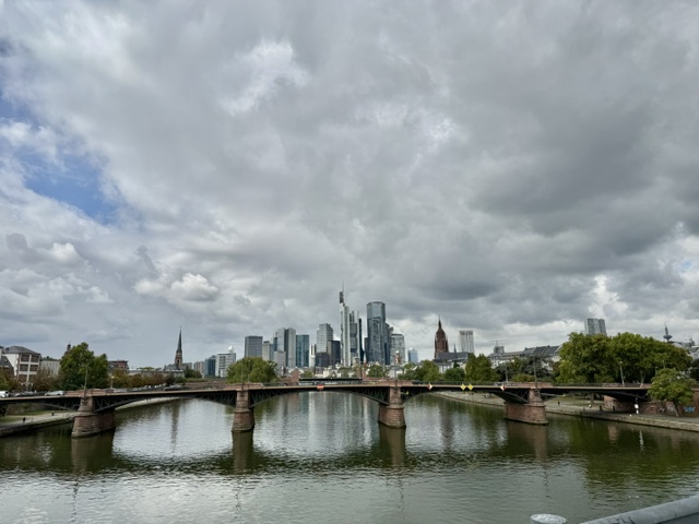 Blick über den Main auf die Frankfurter Skyline und die Alte Brücke bei bewölktem Himmel