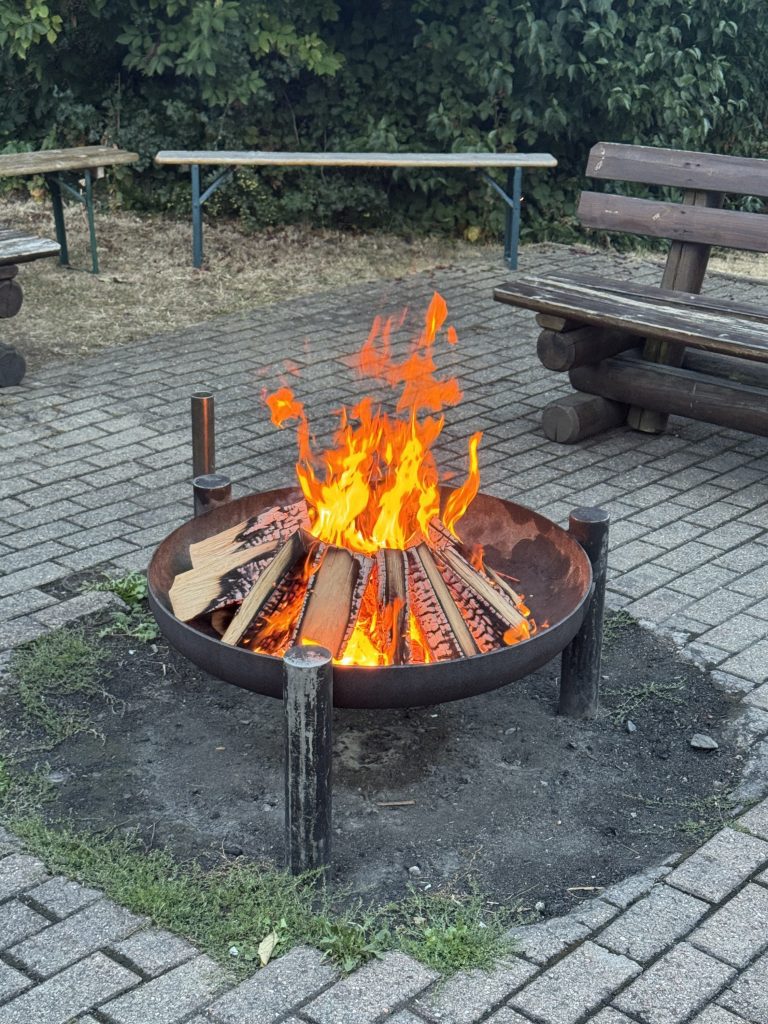 Lodernde Feuerschale mit Sitzbänken, Lagerfeuer bei der Klassenfahrt Jahrgang 4 nach Höchst im Odenwald