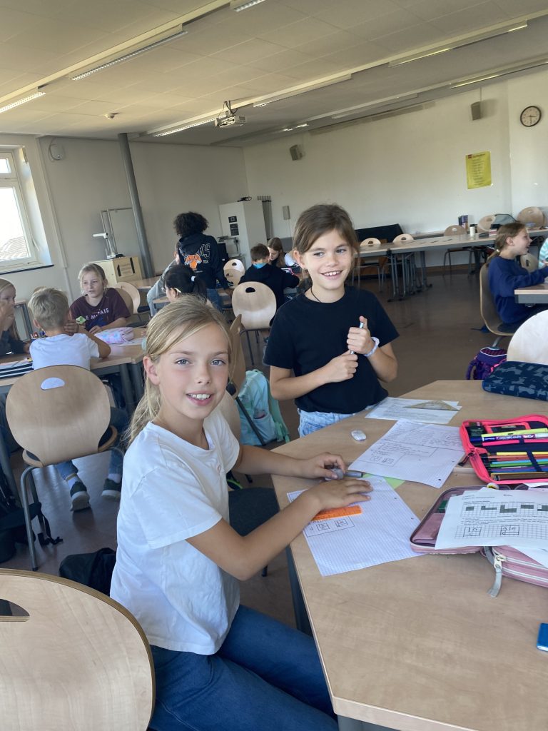 Kinder sitzen im Klassenraum an Tischen mit Arbeitsblättern, Mathematikworkshop der Schillerschule Jahrgang 4
