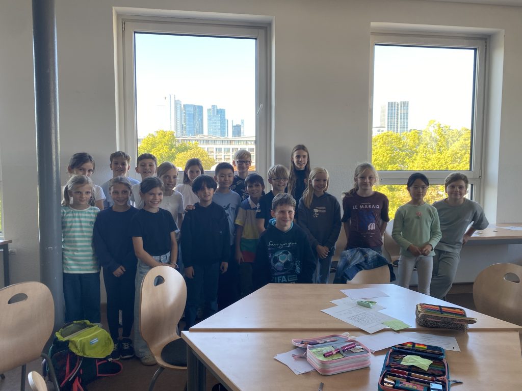 Gruppe von Kindern steht vor den Fenstern im Klassenraum, Mathematikworkshop der Schillerschule Jahrgang 4