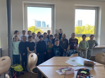 Gruppe von Kindern steht vor den Fenstern im Klassenraum, Mathematikworkshop der Schillerschule Jahrgang 4