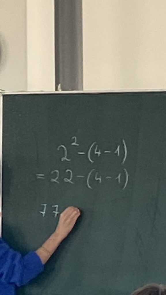 Tafel mit einer Rechenaufgabe mit Klammern und Potenz, Mathematikworkshop der Schillerschule Jahrgang 4